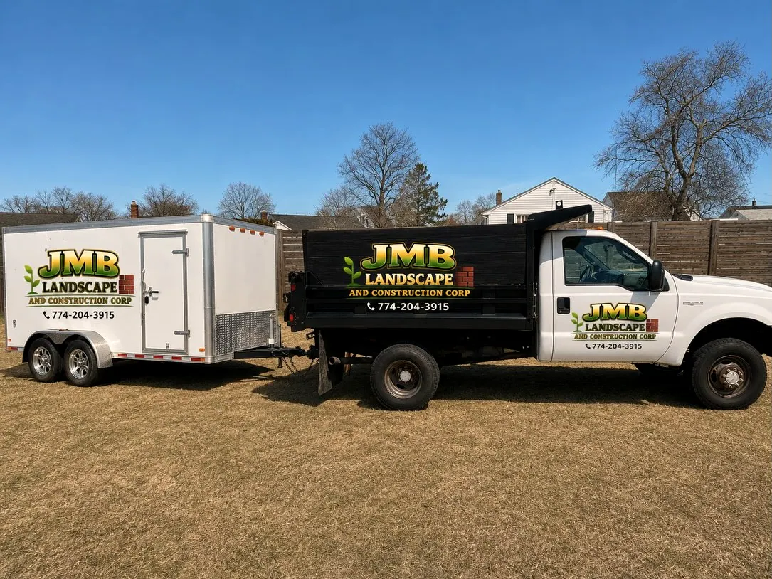 JMB Landscape and Construction Ford dump truck towing a white enclosed trailer, both lettered with the logo